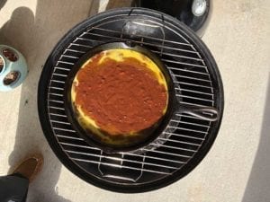 Skillet of brownie batter on top cooking grate
