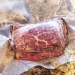 Four ounce portion of sliced pastrami frozen in vacuum bag