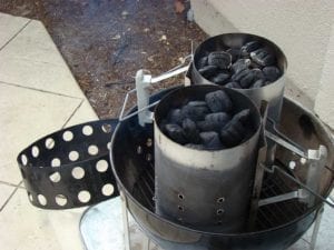 Two Weber chimney starters lighting Kingsford charcoal