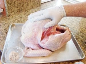 Applying rub to turkey skin