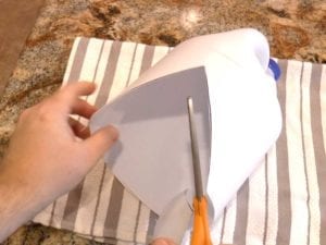 Use a ruler and marking pen to draw a V on the side of the bottle in line with the handle, then cut out the V