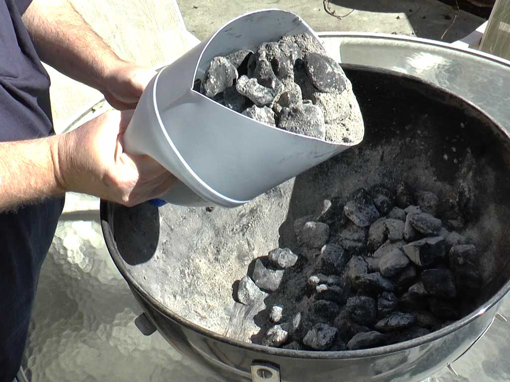 Using the homemade ash shovel to scoop ashes from the WSM