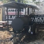 Mobile smoker with Black's signs in background