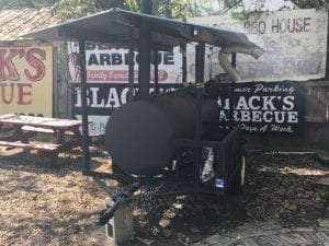 Mobile smoker with Black's signs in background