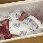 Brisket inside Styrofoam cooler with frozen ice gel packs