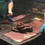 Sausage rings and ribs laid out on butcher block