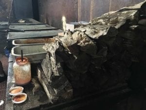 View of smoke wood pile next to pit