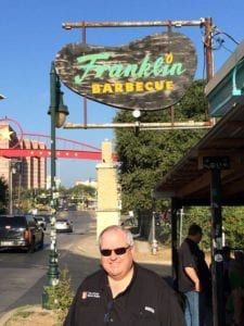 Chris Allingham posing with the Franklin Barbecue sign