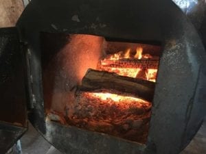 Post oak burning in a pit's firebox