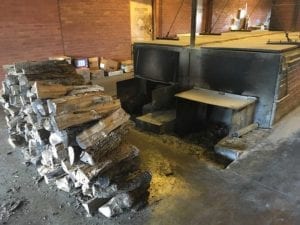 Stacked split logs near two pits