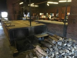 Looking across pits toward the meat cutting area and front counter