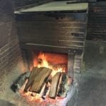 Open wood fire drafts into a backroom pit