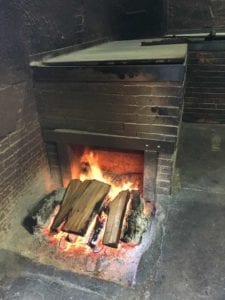 Open wood fire drafts into a backroom pit
