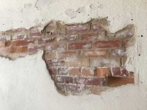 Plaster and exposed brick in overflow dining room