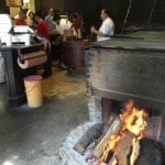 Pit room with wood fire burning on floor next to pit