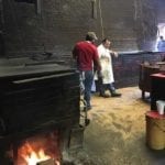 Open fire at end of pit and sawdust covered floors