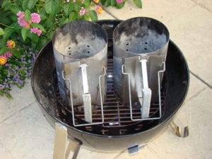 Two Weber chimney starters on charcoal grate