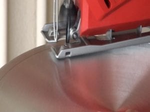 Close-up of jigsaw cutting the pot