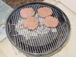Burgers over the charcoal bowl
