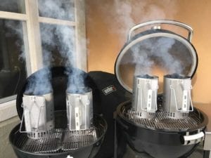 Identical Weber chimney starters over disposable foil pans