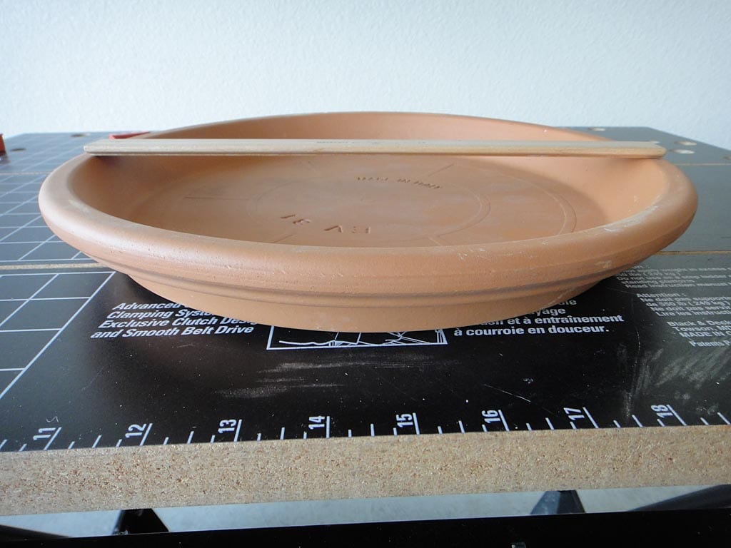 Side view of terra cotta clay saucer used as a heat diffuser