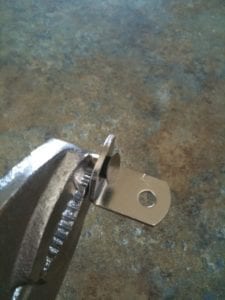 Removing support bracket pin with pliers