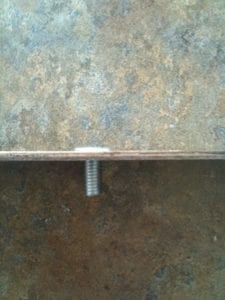 Screw inserted through back side of grill strap