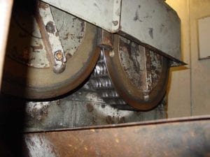 Rotating press rolls form two briquettes side by side. The wheel on the right makes the Sure Fire Groove impression.