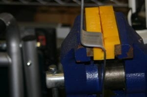 Bending the lid hanger in a bench vise