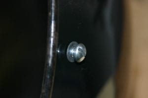 Inserting screw through fiber washer and lid hole