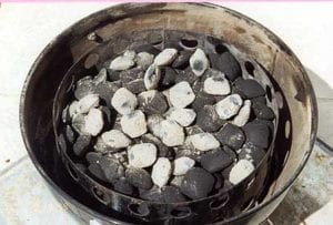 Hot coals spread over unlit briquettes