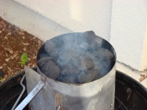 Close-up of lighting a chimney starter