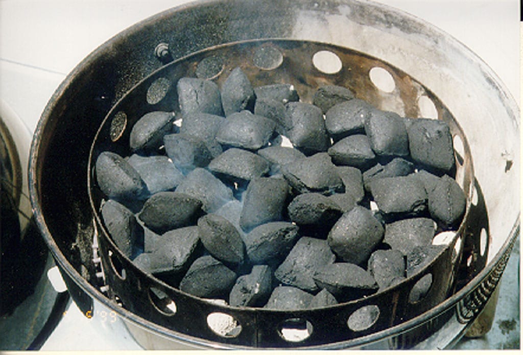 Unlit briquettes over hot coals