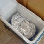 Foiled briskets resting in an empty cooler