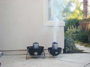 Competition Briquets (right) produce a tall plume of white smoke compared to "blue bag" briquettes (left)