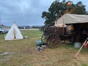 Chuck wagon nosed under a canopy and nearby teepee tent