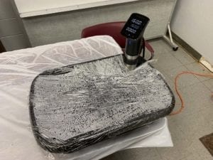 Previously cooked brisket warming in sous vide bath