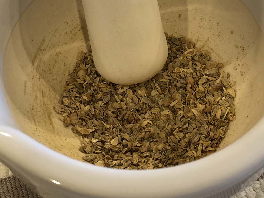 Grinding coriander with mortar and pestle