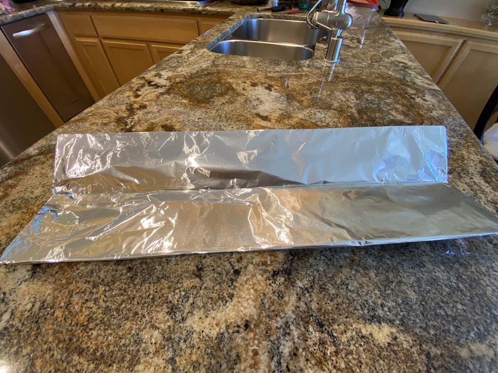 Charcoal chute wrapped in aluminum foil