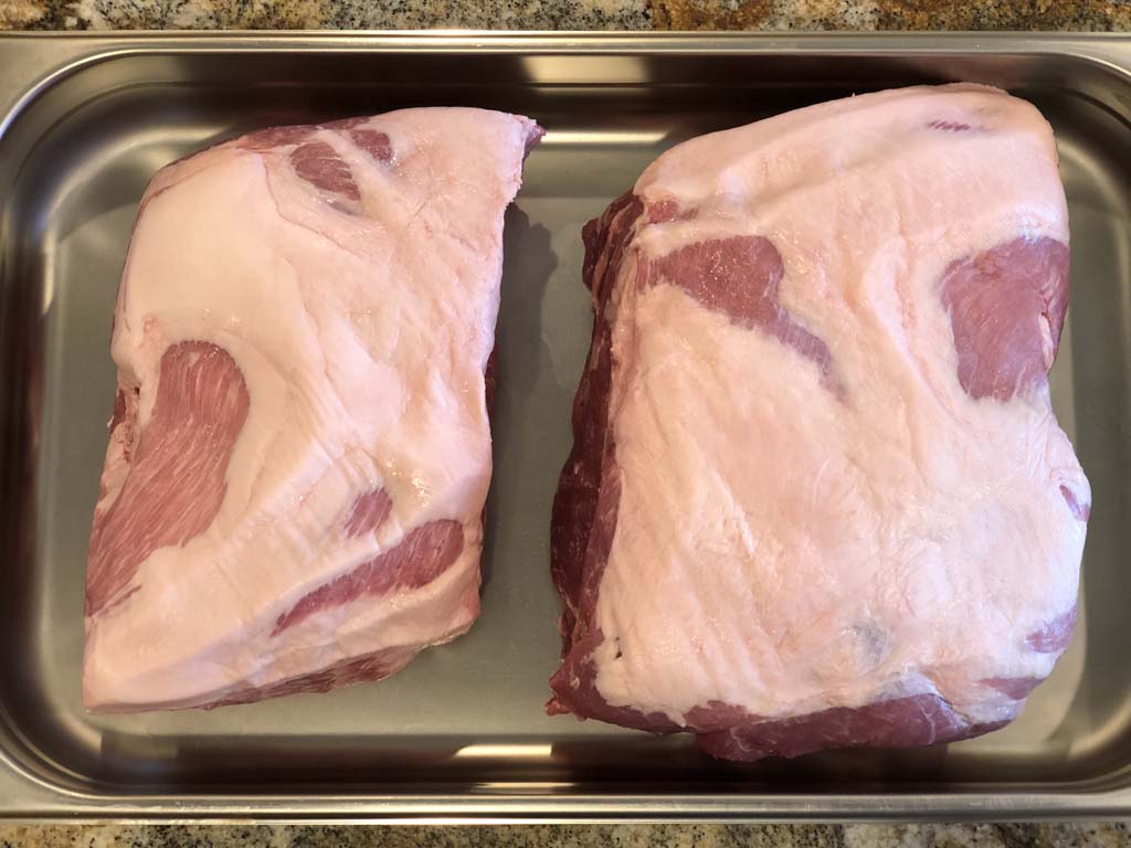 Two pork butts with fat caps on
