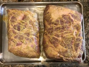 Pork butts slathered with brown mustard