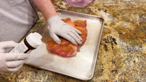 Applying rub to pork butt