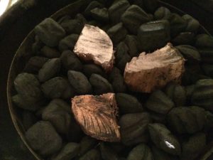 Smoke wood chunks nestled into unlit charcoal
