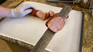 Slice of pork tenderloin on knife blade