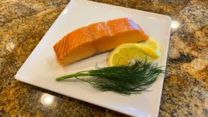 Simple smoked salmon on plate with lemon and dill