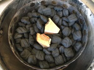 Adding unlit briquets and smoke wood to charcoal chamber