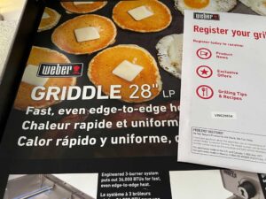 Point-of-sale ad on Weber Griddle with owner's manual showing serial number