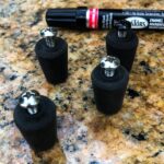 Four knobs with pen used to color screw heads